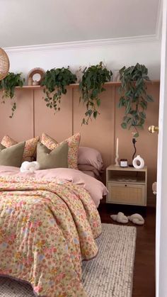 a bedroom with pink walls and plants on the headboard