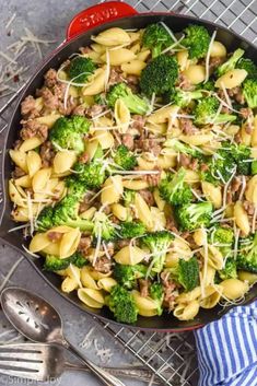 a skillet filled with pasta and broccoli on top of a metal pan