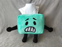 a stuffed toy with a tissue box on it's head and arms, sitting on a bed