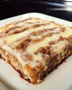 a piece of cinnamon roll cake sitting on top of a white plate with icing