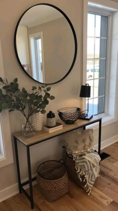 a living room with a mirror, plant and two wicker baskets