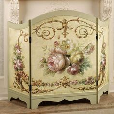 an ornate painted fireplace screen with flowers on it