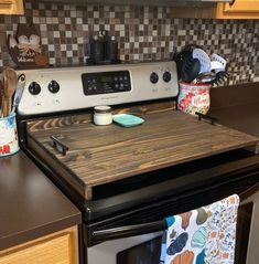 a stove top oven sitting inside of a kitchen next to a counter with pots and pans on it