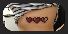 a woman's thigh with four red hearts tattooed on her lower side ribcage