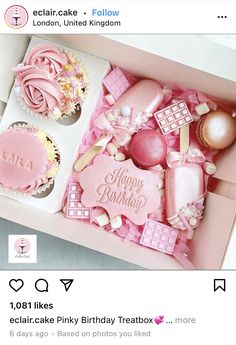 a pink box filled with cupcakes covered in frosting