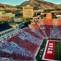 an aerial view of a football stadium with fans in the stands and mountains in the background