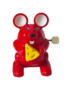 a red toy mouse with cheese on it's chest and ears, holding a piece of cheese in its hand