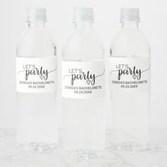 three clear water bottles with labels on them