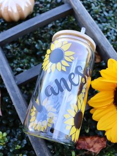 a mason jar with sunflowers next to it and the word one painted on it