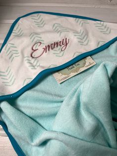 a blue and white blanket with an embroidered name on it