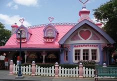 a pink and blue house with hearts on the roof