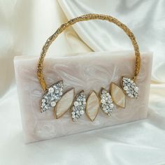 a white purse sitting on top of a table next to a white cloth covered wall