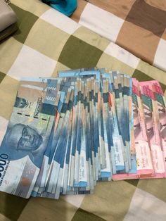 several stacks of money sitting on top of a checkered table cloth