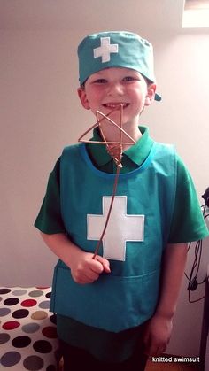 a young boy wearing a green shirt with a white cross on it