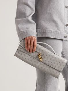 Bottega Veneta's 'Long Andiamo' clutch highlights the house's distinctive leather craftsmanship and attention to detail. It's woven using the brand's signature intrecciato technique and has a unique knot toggle fastening made from polished gold-tone metal. There's enough space inside for your phone, cardholder and lipstick - perfect for events when you don't have much to carry. Luxury Clutch With Intrecciato Weave, Designer Textured Leather Evening Clutch, Designer Textured Leather Clutch For Evening, Luxury Textured Leather Clutch For Office, Designer Evening Clutch With Intrecciato Weave, Luxury Evening Clutch With Intrecciato Weave, Andiamo Clutch, Bottega Veneta Clutch, Play Shop