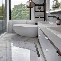 a bathroom with a large bathtub next to a walk in shower and two sinks