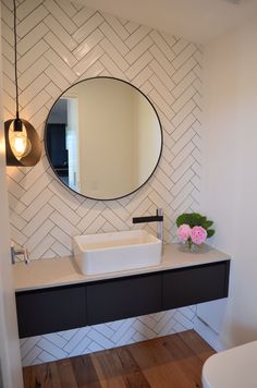 a bathroom with a sink, mirror and lights on the wall next to a toilet