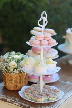 three tiered trays filled with cupcakes and muffins on top of a table