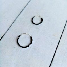 Black Hoop Earrings made by Silver Sterling 925. You can choose Size: - 10mm diameter x 1,2mm - 12mm diameter x 1,2mm - 14mm diameter x 1,2mm The black color is achieved by enameling silver with Ruthenium. In the seafaring tradition, the number of rings a sailor wore indicated the voyages he had completed. 1 hoop Cape Horn, 2 Cape of Good Hope, 3 Hoops around the world. Our earrings are sent in wooden boxes silk-screened by us, the boxes are made of recycled wood from the North of Galicia (Spain Small Black Hoop Earrings For Everyday, Black Hoop Earrings For Everyday, Black Everyday Hoop Earrings, Everyday Black Hoop Earrings, Everyday Small Black Hoop Earrings, Black Nickel-free Hoop Earrings As Gift, Nickel Free Black Hoop Earrings Gift, Nickel-free Black Hoop Earrings Gift, Adjustable Black Hoop Earrings With Ear Wire