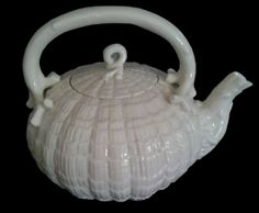 a white ceramic tea pot sitting on top of a table