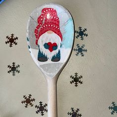 a spoon with an image of a gnome on it and snowflakes in the background