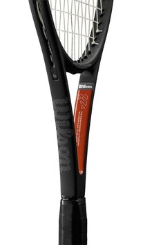 a black and white tennis racket with an orange logo on the back of it