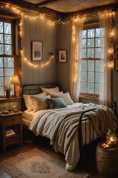 a bedroom with lights strung from the ceiling and a bed in front of two windows