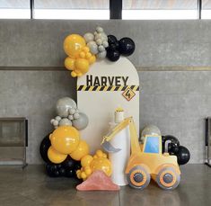 a construction themed birthday party with balloons and decorations on the wall, including an excavator