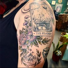 a woman with a book and flowers on her arm that says the reader is reading