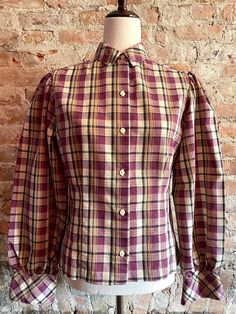 "Beautifully made cotton blouse by College Town, in a late 1970's prairie style with slightly puffed sleeves and a fitted bodice with tucked seams for shaping. The shirt is in excellent condition and appears to have hardly been worn. The tag lists it as a Size 9/10 which translates to a contemporary Size 6 or smaller. Shoulder to shoulder measures 14\" across, bust is 35\" and waist is 31\".  The sleeves measure 24\" from shoulder seam to wrist." Fitted Button-up Blouse With Gathered Sleeves, Classic Fitted Blouse With Gathered Sleeves, Fitted Plaid Puff Sleeve Blouse, Classic Fitted Puff Sleeve Top, Plaid Fitted Blouse With Puff Sleeves, Fitted Plaid Blouse With Puff Sleeves, Fitted Cotton Top With Bishop Sleeves, Fitted Cotton Tops With Bishop Sleeves, Fall Fitted Puff Sleeve Top With Gathered Sleeves