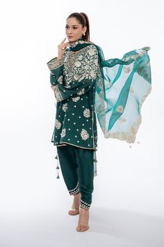 A short emerald green khaddi corduroy shirt with aari and tilla embroidery is paired with a matching worked organza dupatta. Playful tassel detailing complements the shirt and an embroidered rawsilk shalwar completes the look. Model Height is 5'6 and Shirt Length is 35' Tilla Embroidery, Sania Maskatiya, Corduroy Shirt, Designer Name, Party Wear Indian Dresses, Eid Collection, Organza Dupatta, How To Dye Fabric, Raw Silk