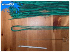 some green yarn and scissors on a wooden table