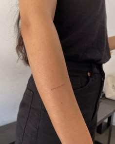 a woman with a small tattoo on her left arm and the word love is written in cursive writing