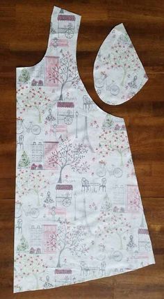 an apron and bib made out of fabric on a wooden floor with a pair of scissors