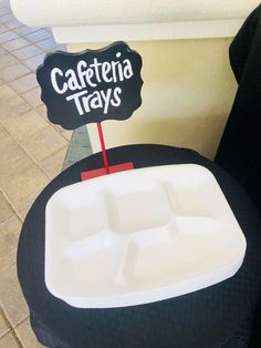 a black and white chair with a sign that says cafeteria trays on the seat