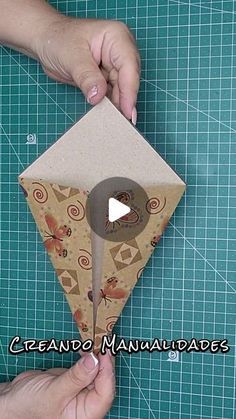 someone is making an origami kite out of cardboard