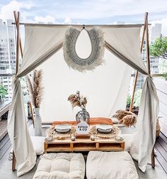 a canopy bed with pillows on top of it in the middle of a roof deck