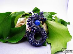 Original pendant depicting a dragon guarding an egg. Made with great care and precision from Toho, Miyuki and Czech FP beads, the dragon egg is an agate ball. The whole thing is hung on a braided strap 48 cm / 18.9inch long Dragon height 8cm / 3.14inch dragon width 4 cm / 1.57inch I can make a dragon in other colors - just write to me:) Fantasy Blue Jewelry For Jewelry Making, Blue Fantasy Jewelry For Jewelry Making, Handmade Blue Fantasy Jewelry, Fantasy Beaded Jewelry As Gift, Unique Agate Beads As Gift, Blue Amulet Beads For Gifts, Blue Amulet Beads For Gift, Unique Pendant Beads As Gift, Handmade Blue Amulet Beads