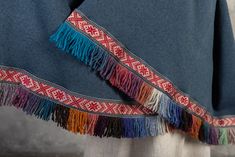 Latvian folk style wide scarf, shoulder shawl with fringes. A nice gift to warm someone up. The soft fabric is used for the base. Edging decorated with wool fringes and woven decorative ribbon. With -77 cm Length of 215 cm You can choose blue, white, grey! Made by SandrasMagic for You! Multicolor Traditional Shawl With Tassels, Traditional Multicolor Shawl With Tassels, Traditional Multicolor Tasseled Shawl, Traditional Fringed Poncho Shawl, Handmade Folk Shawl For Winter, Traditional Winter Shawl With Tassels, Handmade Folk Shawl Scarf, Traditional Fringed Shawl Scarf, Traditional Shawl Scarf With Fringe