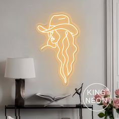 a neon sign with a man's face wearing a cowboy hat on the wall