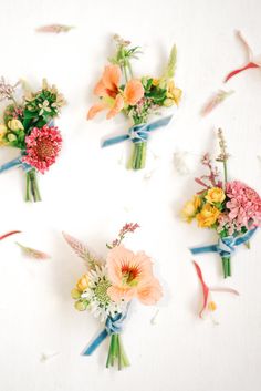 six bouquets of flowers are arranged on a white surface