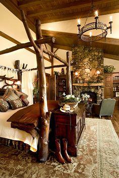 a bedroom with a stone fireplace and wooden furniture