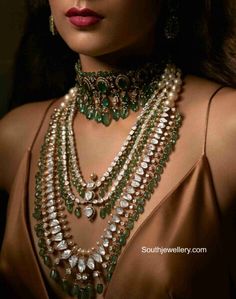 a woman in a brown dress wearing green and white necklaces with pearls on her neck