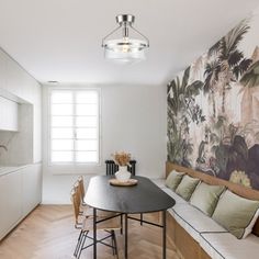 a dining room table and bench in front of a wall mural