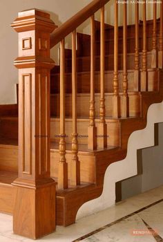 a wooden stair case next to a tiled floor