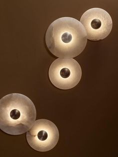 three lights that are on the ceiling in a room with brown walls and flooring