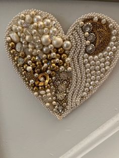 a heart shaped brooch is adorned with pearls