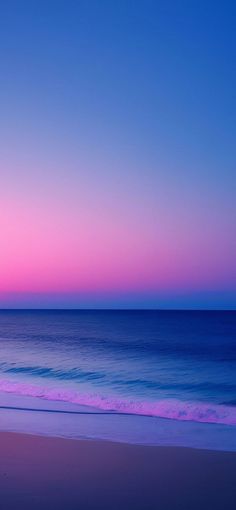 the sun is setting over the ocean with pink and blue colors in the sky above