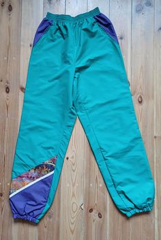 Artsy looking sport pants with lining. Great condition, 2 secure side pockets. Asymmetric design. Pants made of windproof material. Measurements; length-104cm, waist- up to 86 cm in circumference. Size M. Green Stretch Parachute Pants For Outdoor, Green Nylon Sports Pants, Green Nylon Sport Pants, Green Parachute Pants With Side Pockets For Sports, Sporty Green Parachute Pants For Outdoor Activities, Green Sporty Parachute Pants For Outdoor Activities, Sporty Green Waterproof Bottoms, Winter Sports Bottoms, Sporty Pants For Winter Sports