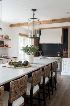 a kitchen with an island and lots of counter space in front of the stove top